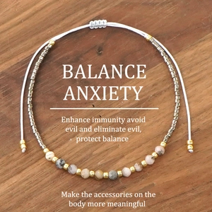 Handmade Miyuki bead bracelet with natural gemstones and adjustable white cord on wood