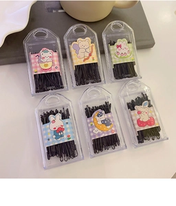 Detail of black bobby pins in six colorful candy-colored boxes with cute cartoon labels