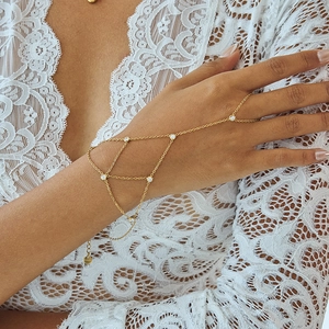 Elegant gold slave bracelet with zircon stones and tassel design on delicate hand