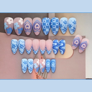 Sky blue and pink almond press-on nails with heart, flower, and checkerboard patterns