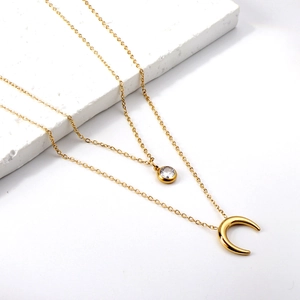 Double-layered gold titanium steel necklace featuring moon pendant and round zircon