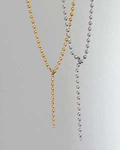 Detail of minimalist gold and silver bead chains showing metallic luster and ring clasp
