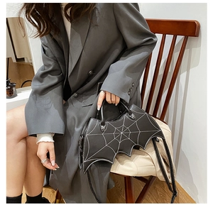 Black PU leather handbag with bat wing and spider web embroidery on a model's arm
