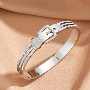 Polished silver belt buckle bangle with triple-row rhinestones on champagne silk