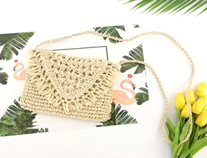 Detail of hand-woven paper rope bag with delicate crochet hollow pattern and fringe