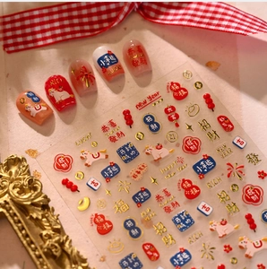 Macro shot of Chinese New Year nail art decals with gold foil lanterns and lucky charms