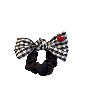 Classic black and white checkered bow scrunchie with a decorative red heart resin charm