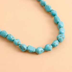 Macro detail of irregular sky blue turquoise beads and natural stone texture on necklace
