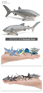 Detailed scale view of a miniature whale shark model held in hand for size comparison
