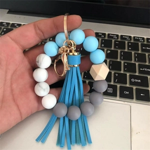 Close-up of silicone beaded keychain with blue leather tassel and gold metal clasp