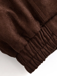 Close-up of dark brown suede jacket detailing smooth fabric texture and precise stitching