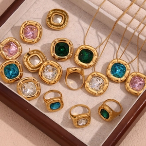 Close-up of vintage 18K gold plated jewelry set with colorful square zircon in a tray