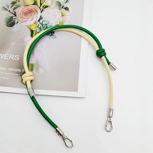Detail of green and beige leather strap with metal clasps on floral magazine background