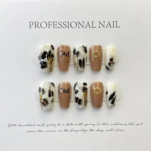 Handmade press-on nails set with grey leopard print and metallic accents on white board