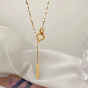 Minimalist gold geometric interlocking square pendant necklace on white silk background