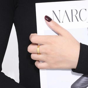 Detailed view of gold Roman numeral ring with small diamonds worn on a finger