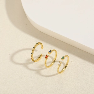 Three minimalist gold open rings with colorful zircon stones in green, blue and red