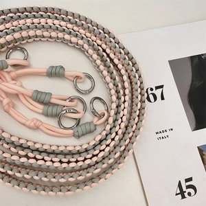 Detail of pink and gray hand-woven wide shoulder strap with silver metal ring buckles