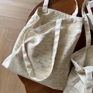Close-up of the textured cotton linen fabric and floral embroidery on this tote bag