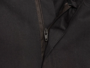 Nahaufnahme des hochwertigen YKK-Metallreißverschlusses auf schwarzem Twill-Stoff am Midi-Rock