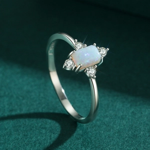 Vintage s925 silver opal ring with side diamonds on green velvet background
