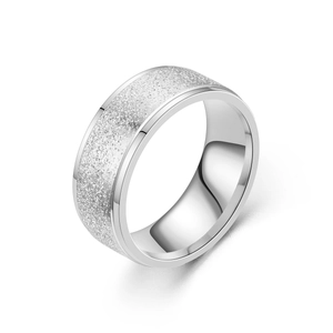 Détail d'une bague en acier argenté avec centre sablé mat et bords extérieurs polis