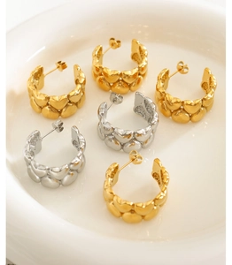 Detailed view of C-shaped earrings with joined heart motifs in gold and silver finish