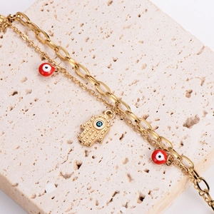Double-layered gold Hamsa hand bracelet with red and blue evil eye charms and chain