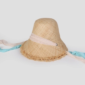 Detail of hand-woven straw hat with pink polka dot ribbons and frayed brim edges