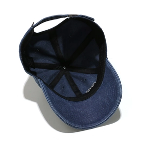 Detail of blue denim baseball cap interior featuring reinforced seams and metal buckle