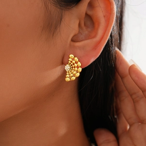Gros plan détaillé de boucles d'oreilles dorées en forme d'éventail avec strass sur un mannequin