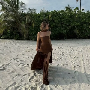 Detail of dark brown strapless maxi dress with side slit and neck scarf in tropical resort