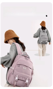 Detail view of the ergonomic widened curved shoulder straps on this lightweight pink backpack