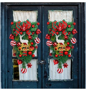 Detail of Christmas teardrop wreath with reindeer and red berries on a blue door