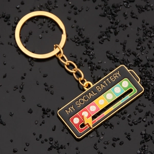 Macro detail of My Social Battery enamel keychain with sliding gold lightning bolt pin