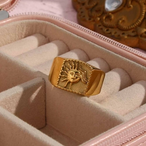Macro shot of 18K gold plated sun face ring placed inside a luxury velvet jewelry box