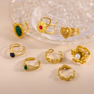 Detailed view of vintage gold ring set with colorful gems, pearls and floral patterns