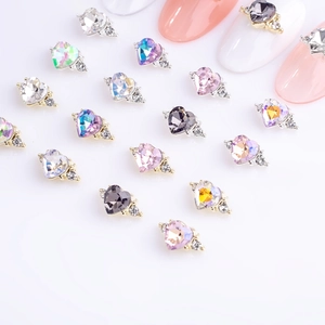 Detailed close-up of 3D heart-shaped alloy nail art charms in various crystal colors