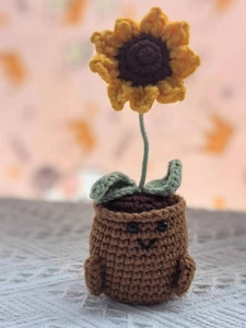 Detailed view of a handmade crochet sunflower in a smiling pot for home decoration