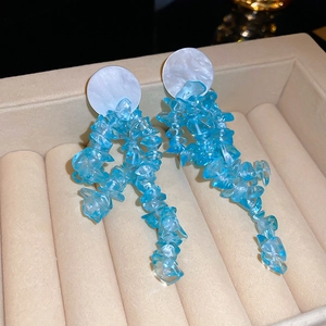 Detail of bamboo round earrings with light blue crystal drop and shell base for women