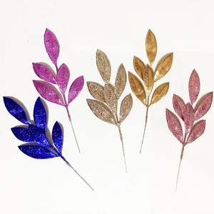 Dettaglio di cinque aghi di pino artificiali glitterati in blu, oro e rosa cipria