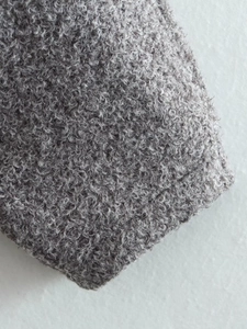 Macro shot of grey bouclé wool fabric texture on this casual street-style jacket