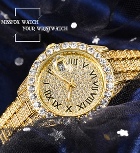 Détail d'une montre de luxe dorée avec strass scintillants et guichet de date intégré