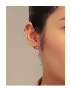 Detail showing high-quality purple zircon stud earrings with gold plating on ear