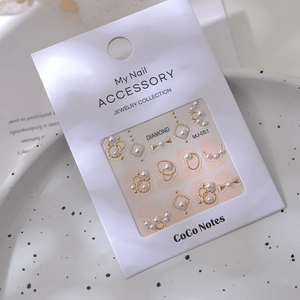 Detail of luxury nail art stickers with pearls, gold rings and 3D bowknot elements