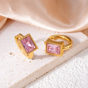 Macro shot of gold huggie earring featuring emerald-cut pink zircon with milgrain detail