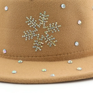 Gros plan de strass colorés formant un flocon de neige sur un chapeau en feutre marron