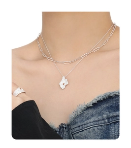 Detail of layered silver necklaces with irregular lava pendant and ruby gemstone