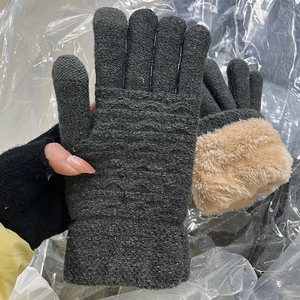 Detail of warm dark grey knitted gloves with wavy pattern and plush fleece lining
