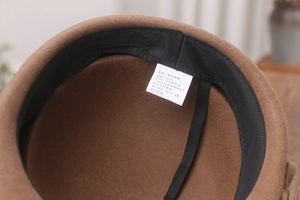 Detail view of the 100% sheep wool interior and size tag of this brown equestrian hat